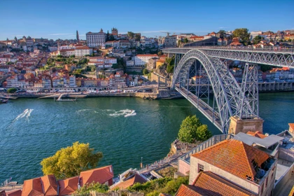 Dom Luís I Bridge spanning the Douro River in Porto, Portugal, with colorful hillside buildings in the background