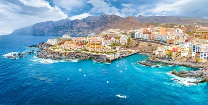 Scenic view of Los Gigantes, Tenerife, with colorful buildings perched on cliffs overlooking the blue Atlantic Ocean