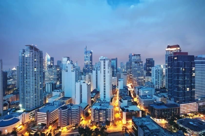 Evening skyline of Manila, Philippines, featuring illuminated skyscrapers and busy streets