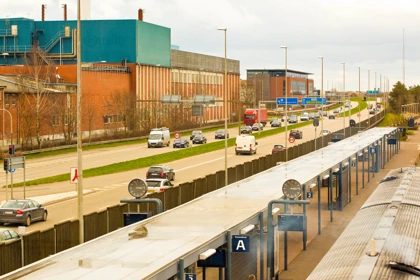 Herning transport hub with a bus terminal, nearby road traffic, and industrial buildings in the background
