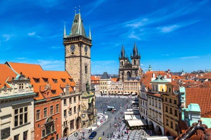 Prague's Old Town Square with the Astronomical Clock Tower and Church of Our Lady before Týn under a clear blue sky