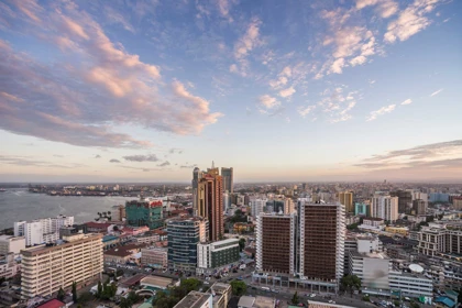 Dar es Salaam city skyline at sunset, featuring modern buildings and the harbor