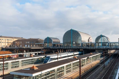 Taastrup Station in Denmark with arched glass structures, train platforms, and a modern passenger train