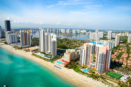 Aerial view of Miami's beachfront skyline with high-rise buildings, turquoise waters, and sandy beaches