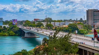 Nyali Bridge in Mombasa, Kenya, spanning turquoise waters with traffic and lush greenery on both sides