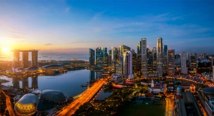 Singapore skyline at sunset featuring Marina Bay Sands, skyscrapers, and illuminated city lights