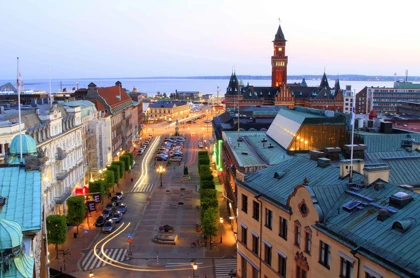 Evening view of Helsingborg, Sweden, featuring historic architecture, light trails, and the illuminated town hall