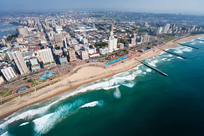 Aerial view of Durban's beachfront with city skyline, sandy beaches, and turquoise ocean waves