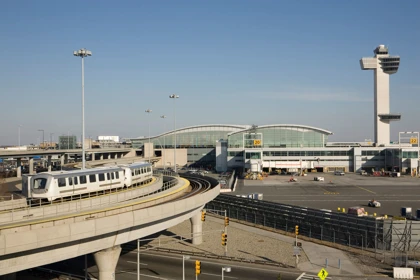 AirTrain at John F. Kennedy International Airport with terminal buildings and control tower in the background