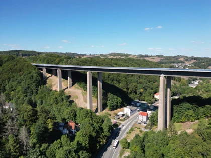 Aerial view of a large bridge near Lüdenscheid, Germany, spanning a green valley with roads and houses below