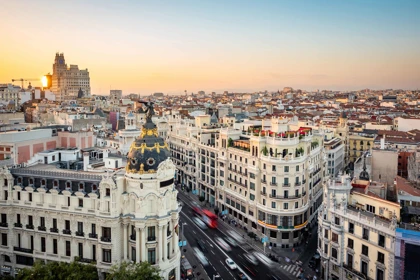 Aerial view of Gran Vía in Madrid at sunset, featuring the iconic Metropolis Building