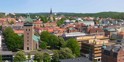 Panoramic view of Borås, Sweden, featuring historic church towers, colorful rooftops, and lush greenery