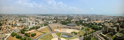 Panoramic view of Lomé, Togo, showing city buildings, greenery, and the Independence Monument in the foreground