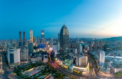 Wuxi skyline at dusk featuring modern skyscrapers, illuminated streets, and urban architecture