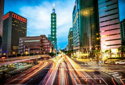 Taipei skyline at night featuring Taipei 101 and vibrant light trails from city traffic