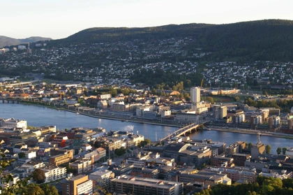 Panoramic view of Drammen, Norway, showcasing the city by the Drammenselva River, a bridge, and forested hills in the background