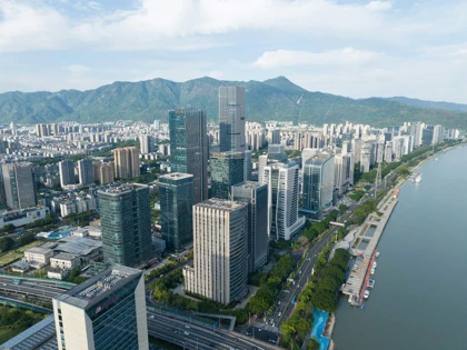 Panoramic view of Fuzhou, China, showcasing modern skyscrapers, roads, and a river with mountains in the background