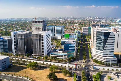 Modern office buildings in Alabang, Manila, surrounded by greenery and urban infrastructure