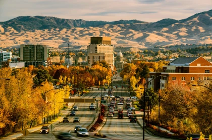 Downtown Boise, Idaho in autumn, with golden foliage, the State Capitol building, and mountains in the background