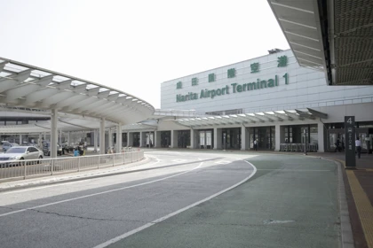 Entrance to Narita Airport Terminal 1 with a curved driveway and drop-off zone under a modern canopy