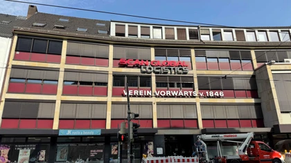Scan Global Logistics office building with red signage on the upper floor in a city street view